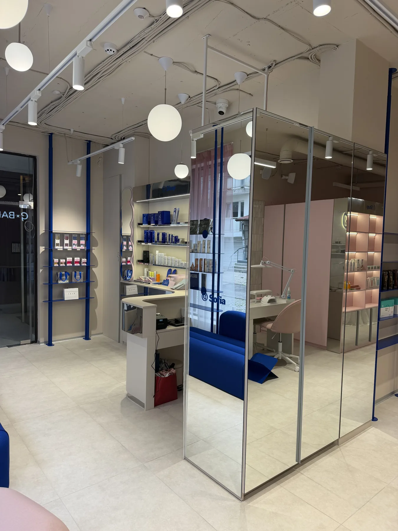 Glass entrance area with product display and blue waiting sofa after G-Bar Sofia renovation