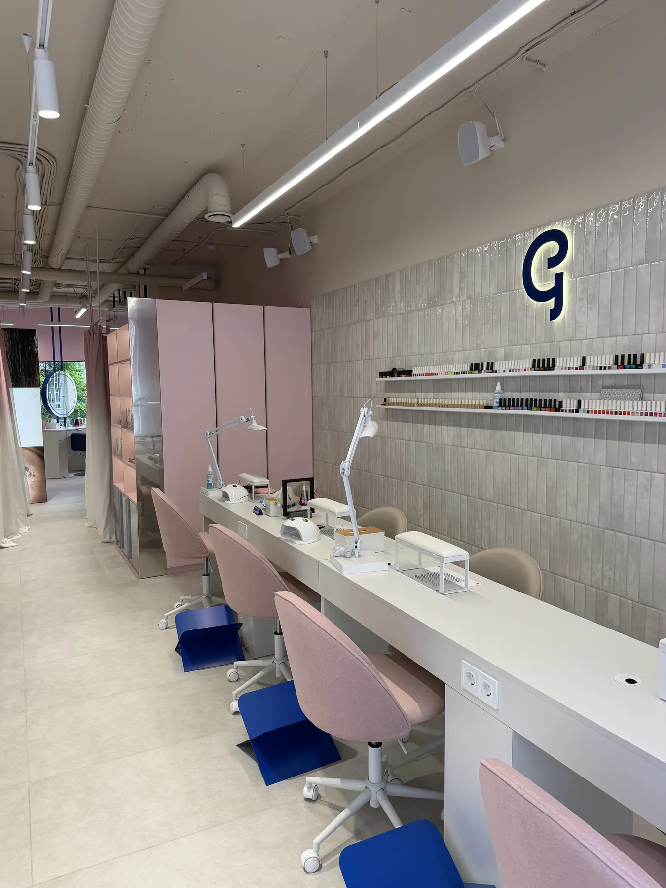 Manicure counter with pink chairs and tiled feature wall in G-Bar Sofia