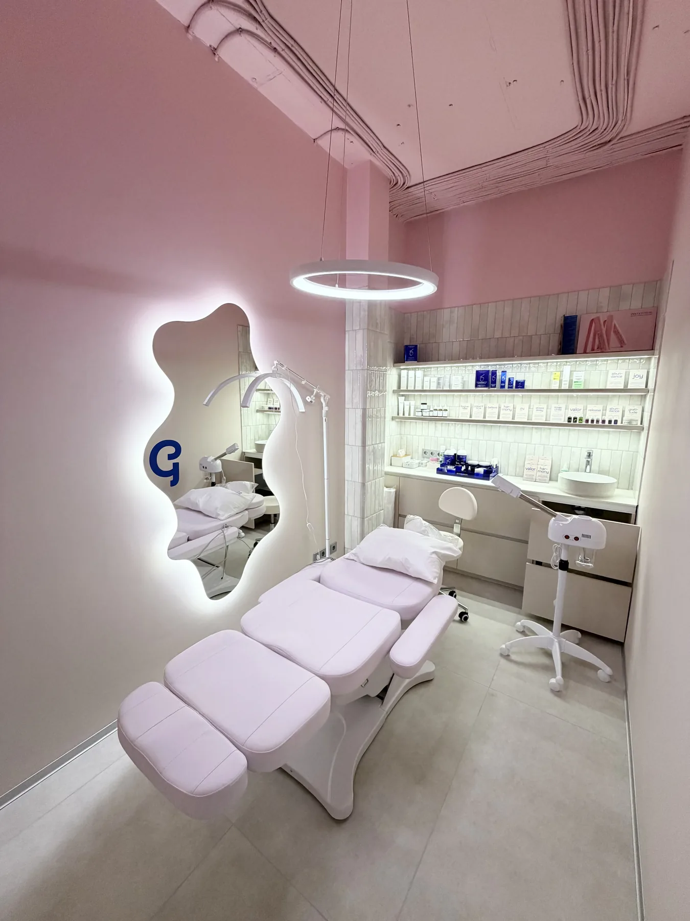 Pink treatment room with beauty chair, illuminated mirror and soft walls