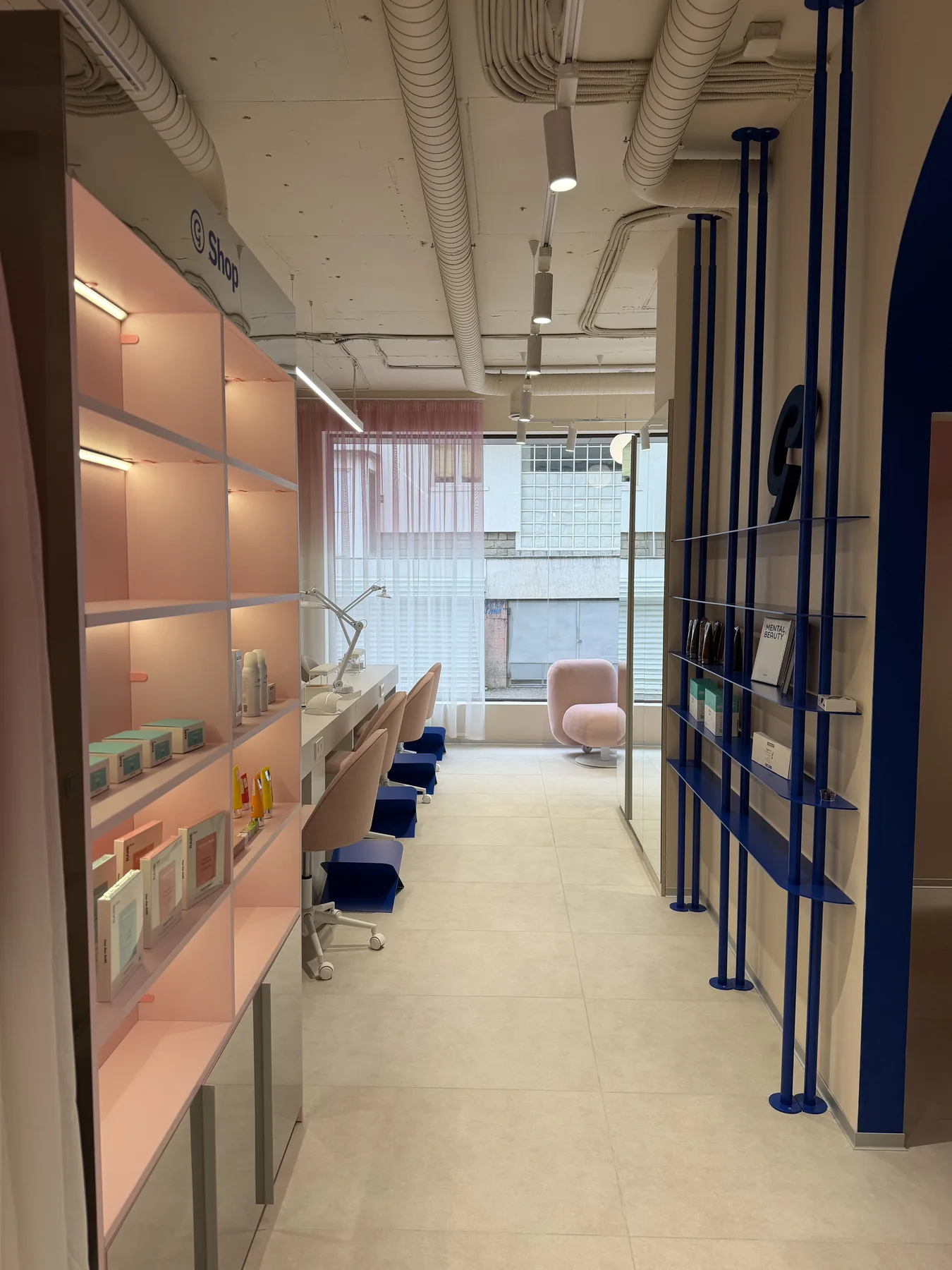 Retail shelving corridor with blue arch and salon circulation