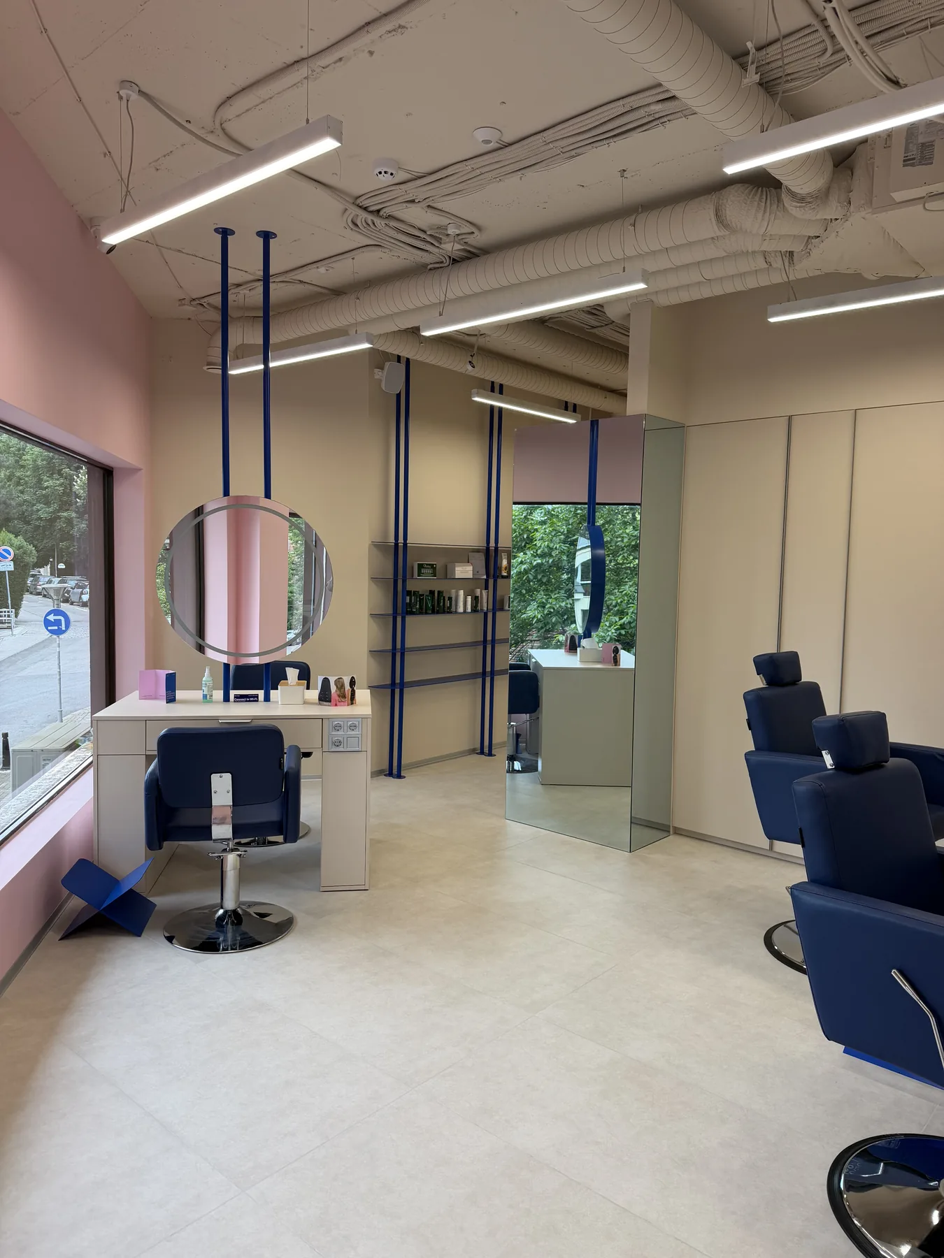 Hair styling station with mirror, blue chair and salon lighting