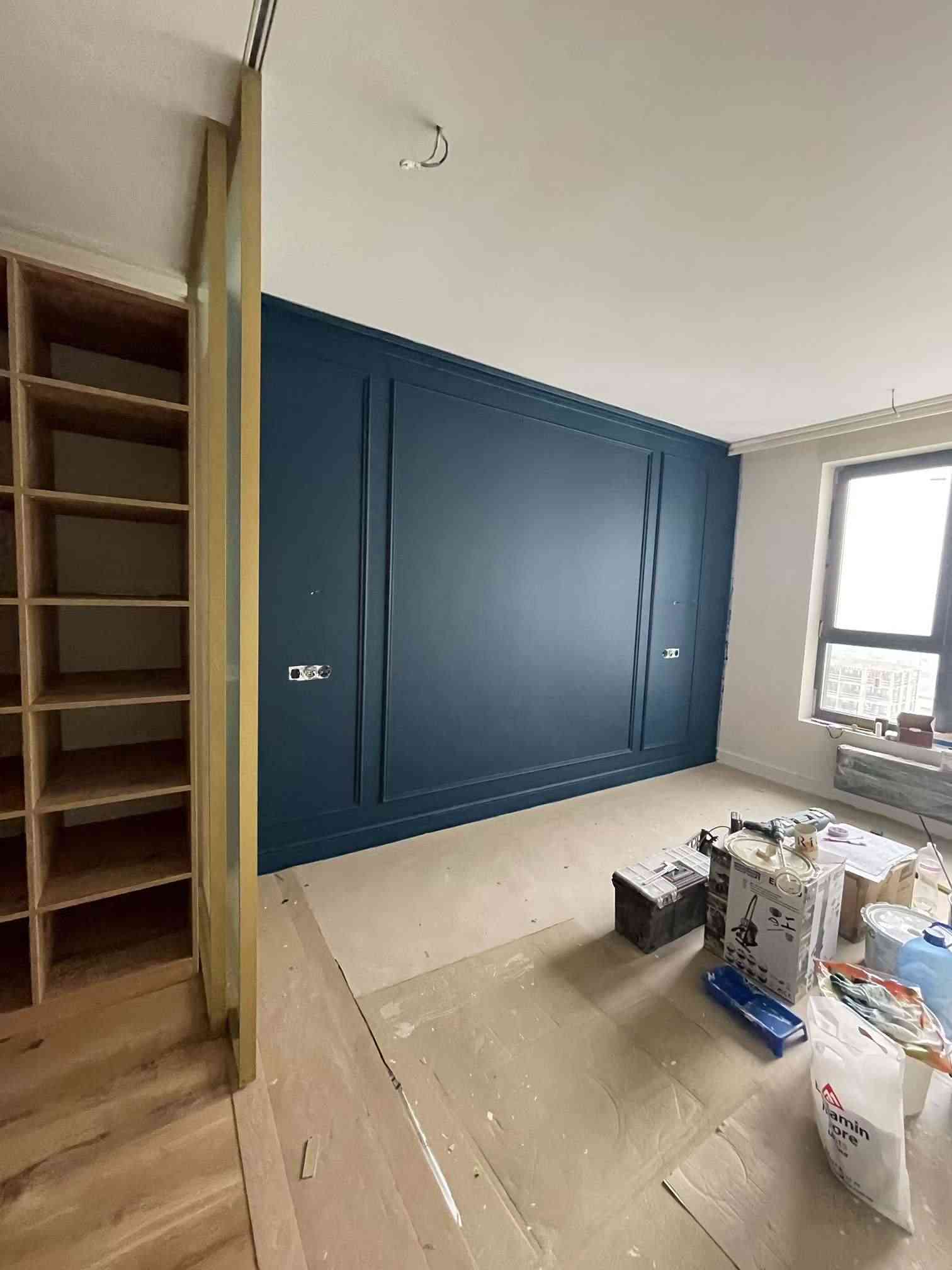 Deep blue accent wall with mouldings and built-in shelving, Rimmart apartment